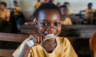 7歲的Mary Afrakomah在加納阿善提地區阿菲格亞Kwabre區的Hemang浮湖D/A小學，手裏拿著一個Vivi包，這是一種以花生為基礎的維生素強化零食，通過好時公司的“激勵學習”項目，每天向加納的5萬名學童提供這種零食。圖片:好時公司